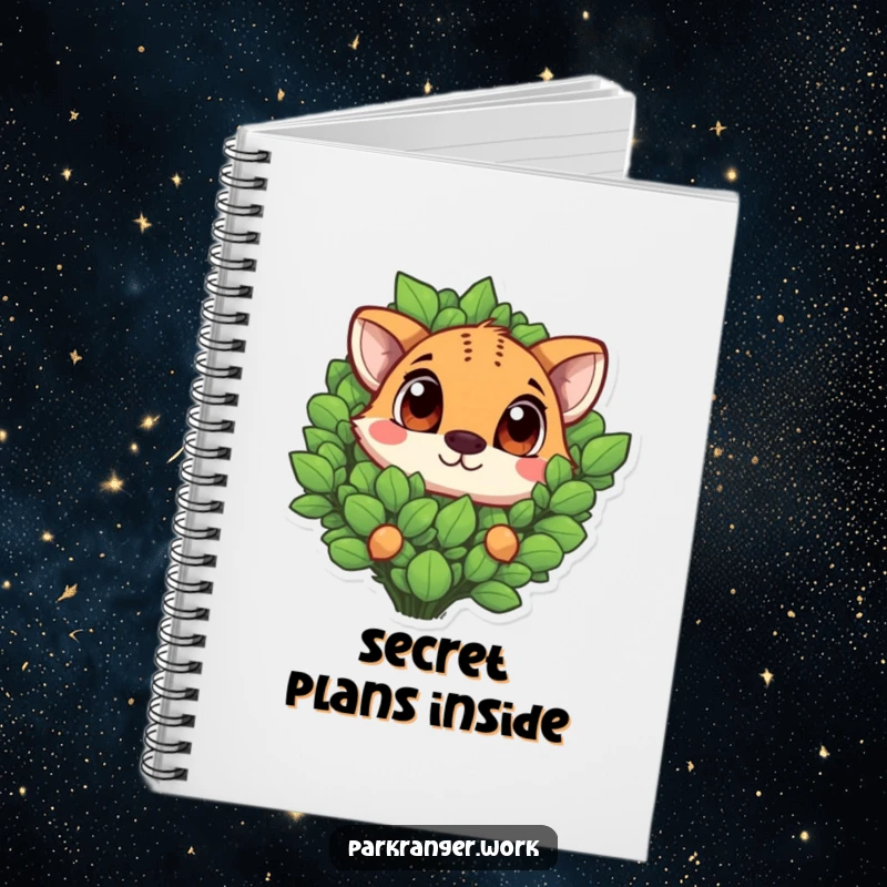 Funny animal with large, expressive eyes peeking out from a green plant, on the cover of a notebook.